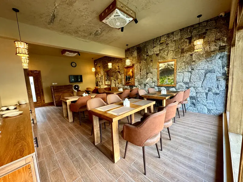 The resort restaurant with a granite feature wall, timber tables and lantern lights